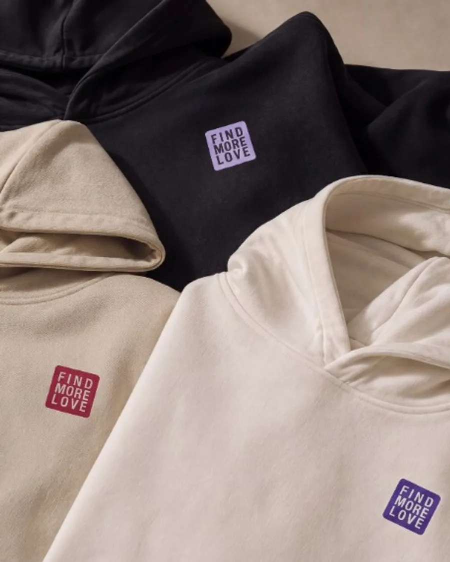 Tres sudaderas oversized FML en negro, arena y hueso, cada una con su parche al pecho